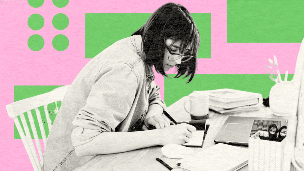 A woman writing at her desk with a laptop, notebooks, and coffee, representing creativity and focused blog writing.