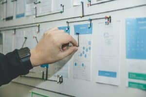 Person mapping out user journey on storyboard wall to improve UX design.
