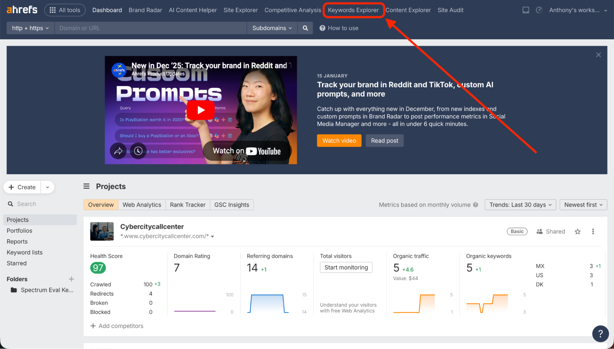 Ahrefs project dashboard interface with a red arrow pointing toward the "Keywords Explorer" tab in the top navigation menu.