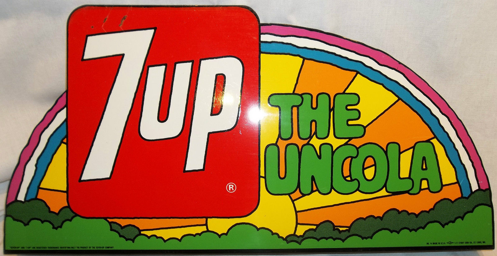 Retro 7-Up ad with a rainbow background and the slogan 'The Uncola,' representing a rebellious and category-defying famous slogan in beverage marketing.