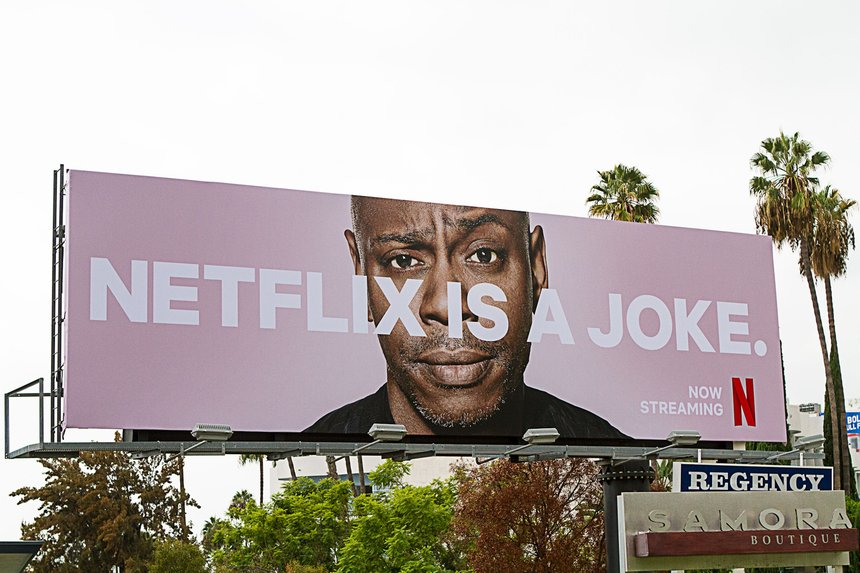 Netflix billboard featuring a comedian's face and the bold slogan 'Netflix Is a Joke,' promoting comedy content and standing out as a clever and provocative famous slogan.