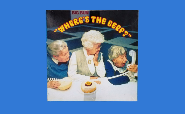 Three elderly women looking at a hamburger bun in the classic Wendy’s ad with the slogan 'Where’s the Beef?', highlighting one of the most humorous and culturally impactful famous slogans.