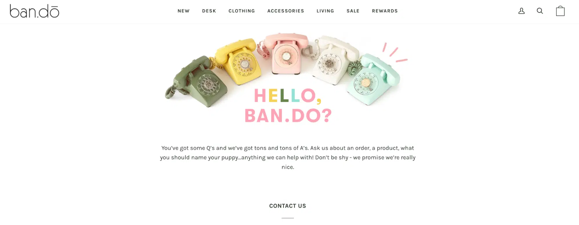 The Ban.do contact page features a playful arrangement of five vintage rotary phones in various pastel colors above the text “HELLO, BAN.DO?” in bold, cheerful typography. A friendly message encourages users to reach out with questions about orders, products, or anything else—even naming a puppy. The design is whimsical and inviting, reinforcing the brand’s fun and approachable personality.
