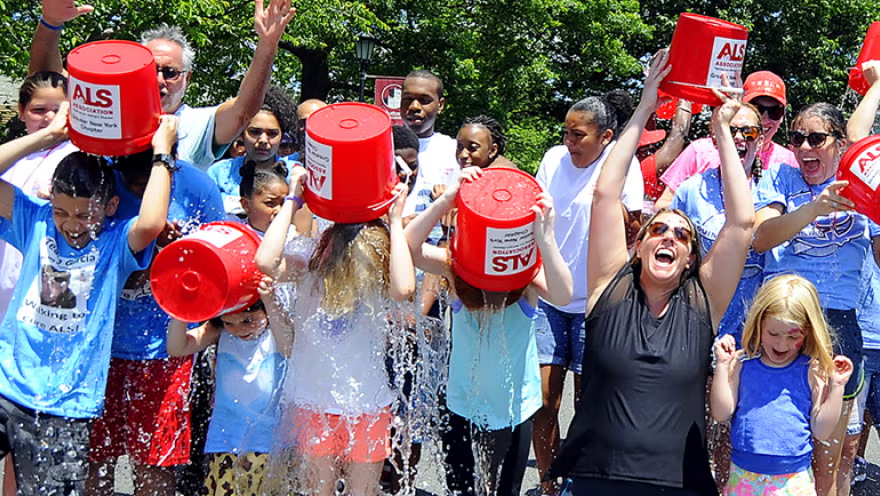 Group of people dumping ice water on themselves as part of the viral ALS Ice Bucket Challenge fundraising campaign.