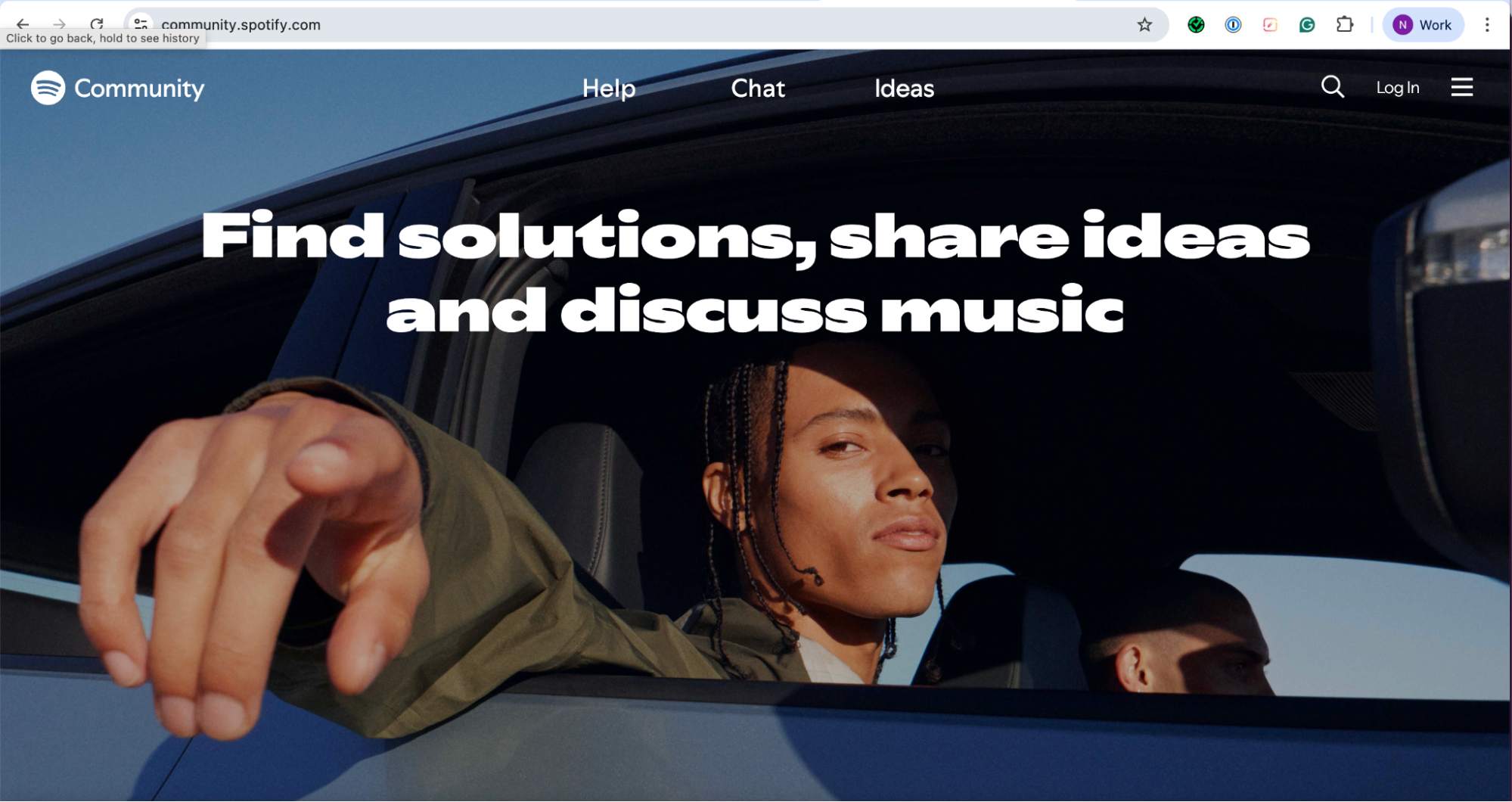 Screenshot of the Spotify Community website (community.spotify.com). The page shows a large banner image of a person leaning out of a car window, pointing toward the camera. The bold text overlay reads: “Find solutions, share ideas and discuss music.” The top navigation bar includes options for Help, Chat, Ideas, a search icon, and a Log In button.