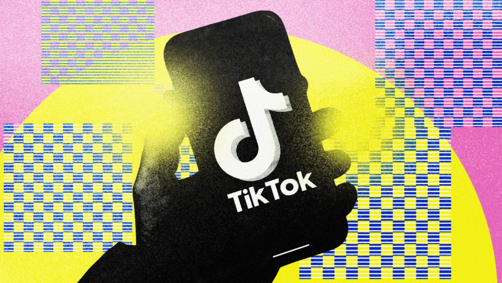 Hand holding a smartphone with the TikTok logo on a colorful background.