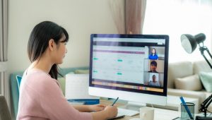 Woman taking notes in front of computer